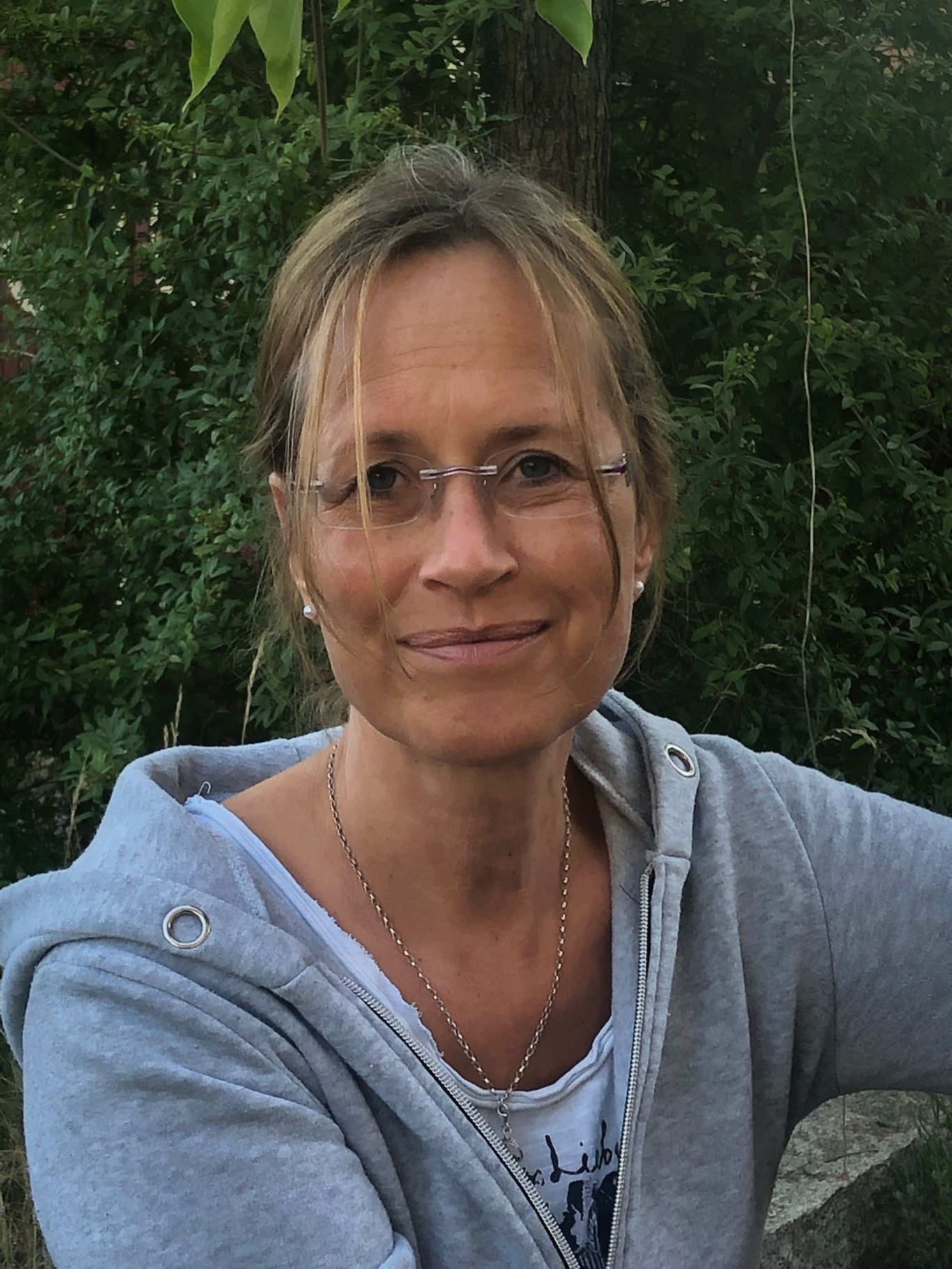 Portrait Foto einer Frau mit Brille und einem Lächeln